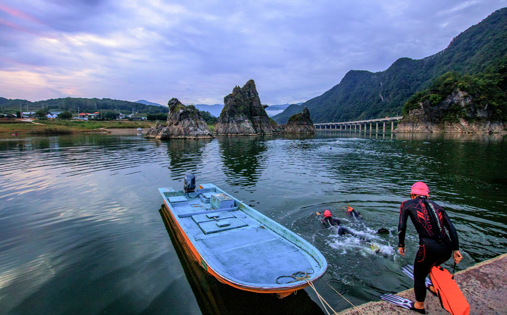 도담삼봉 앞 강가에서 수트와 오리발을 착용하고 수영하는 모습